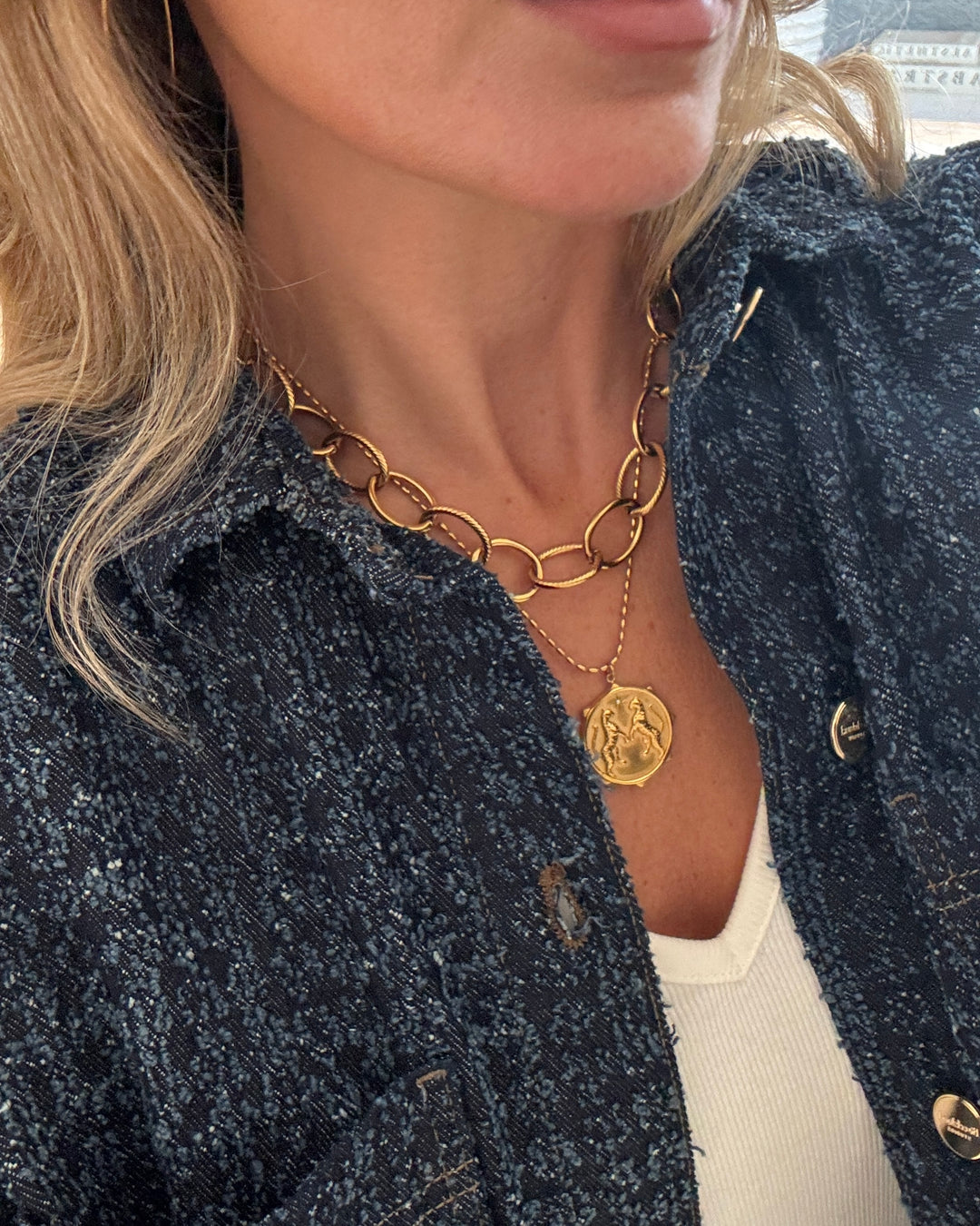 a woman wearing a gold necklace
