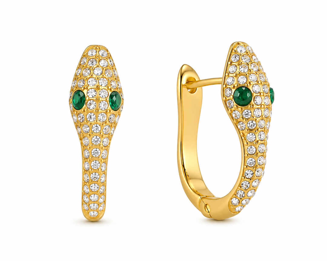 a pair of gold earrings with diamonds and green eyes