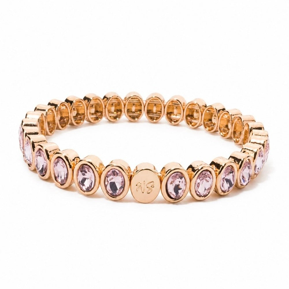 a gold bracelet with pink stones