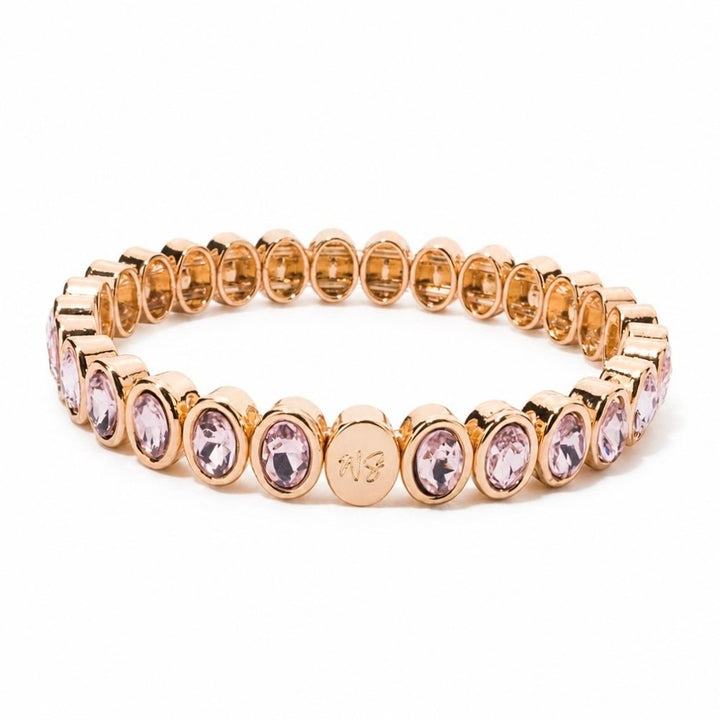 a gold bracelet with pink stones