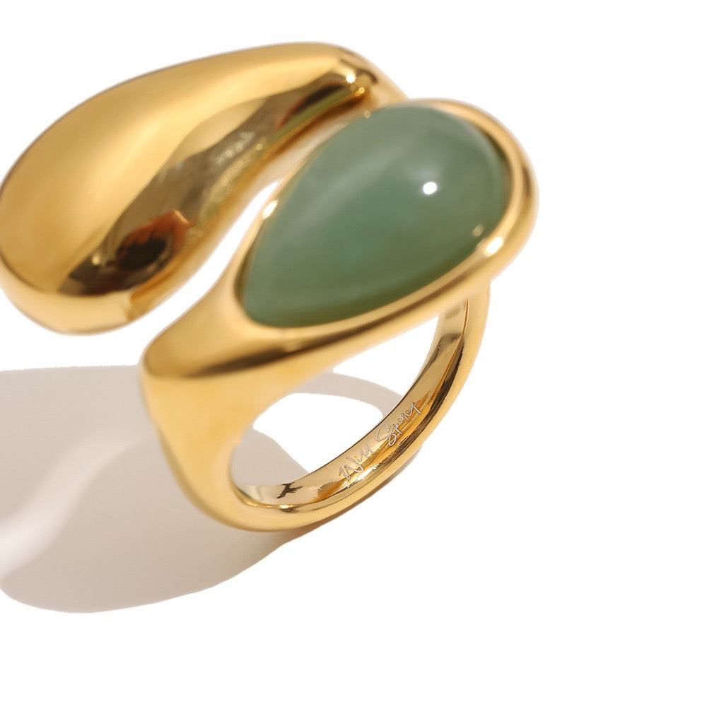 a gold ring with a green stone