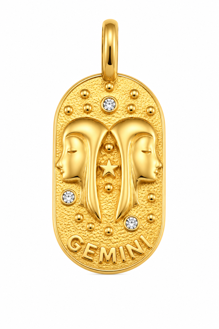 a gold pendant with two faces and diamonds