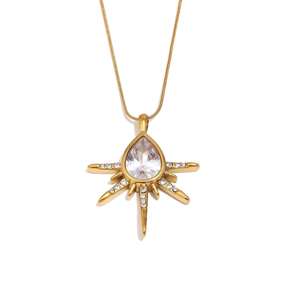 a gold necklace with a large stone pendant