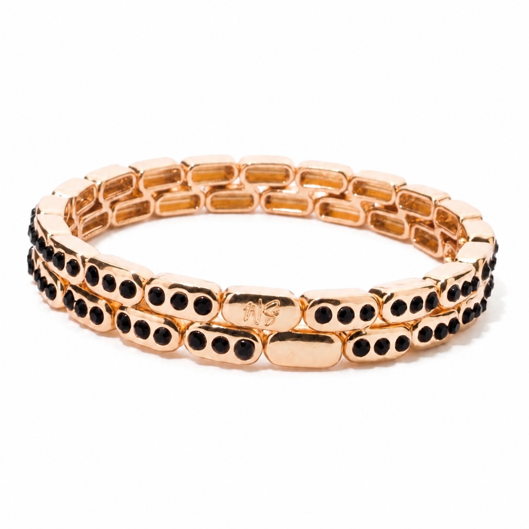 a gold bracelet with black stones
